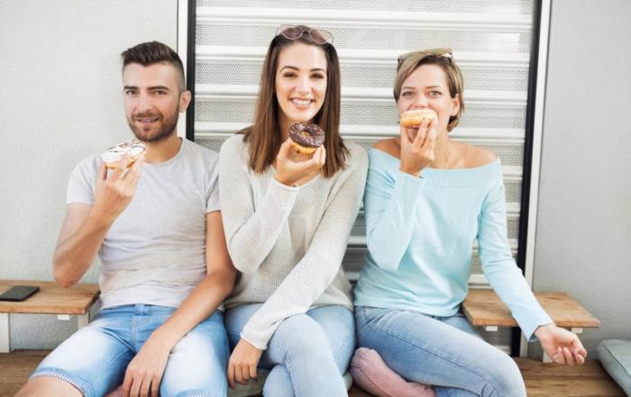 3 friends outside, eating donuts